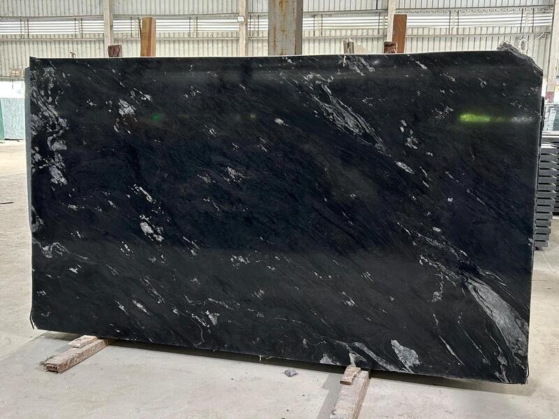 Ocean Black granite slab with white and grey flowing streaks on a dark background