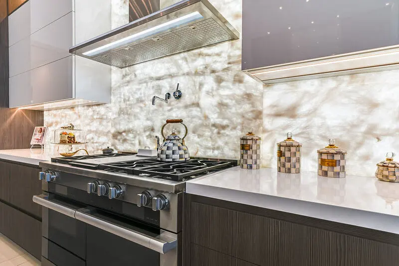 Image: Backlit Cristallo Quartzite backsplash glowing with natural translucent patterns in a modern kitchen setting.