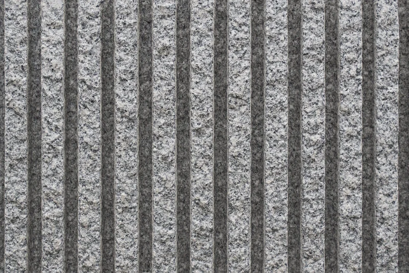 Ribbed granite wall panel with textured linear ridges for architectural cladding and contemporary stone design