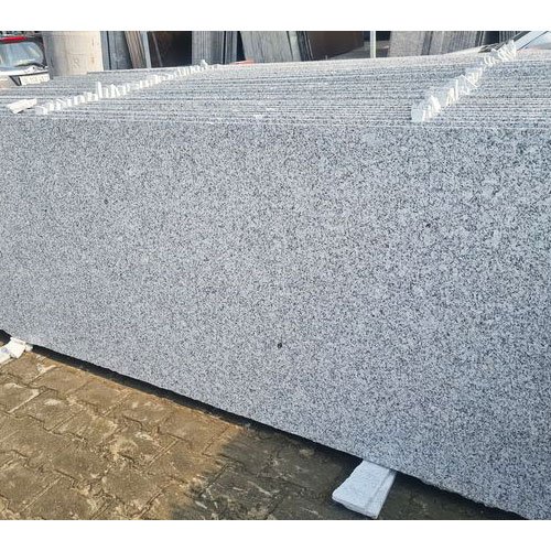 A polished slab of S White Granite featuring a uniform light grey to white background interspersed with fine, densely packed black and dark grey grains, speckles, and granular dot-like mineral patterns, giving a classic salt-and-pepper stone appearance.