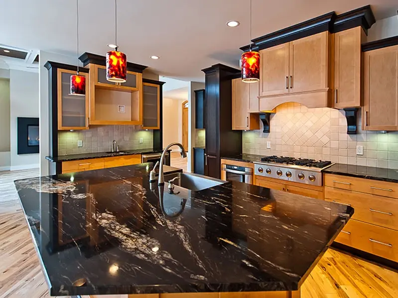Titanium Gold Granite kitchen island countertop with sweeping gold and white veins across a black base—striking black granite with gold elements.